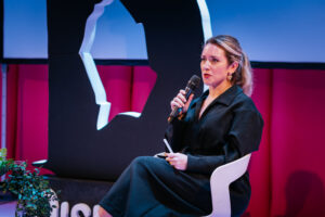 Author Sue Rainsford in mid conversation on stage. Sue was part of an in conversation with artist Porcelain Delaney where they spoke about topics including endometriosis, as part of International Women's Day.