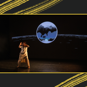 An action shot of Chisato Minamimura in their performance of ‘Mark of a Woman’. They are wearing a white linen outfit, warm toned. Behind them we see a video projection, cool toned and showing a large circle that looks like a lanscape scene within and some lines across the screen.